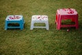 Brightly colored chairs arranged in a row in an outdoor grassy area