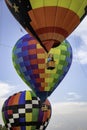 Three brightly colored hot air balloons hover tethered above the ground.