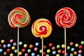 Three brightly colored red themed lollipops