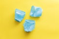 Three broken blue plastic disposable cups over a yellow background Royalty Free Stock Photo