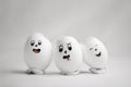 Three broken eggs with funny emoticons