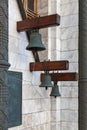 Three bronze church bells hang from wooden beams