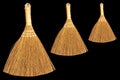 Three brooms isolated on a black background. Space for lettering and design