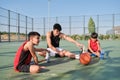 Three brothers doing leg stretching exercises, one of them has a leg prosthesis