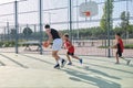 Three brothers playing basketball, one of them has a leg prosthesis Royalty Free Stock Photo