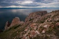 Three Brothers Rocks on Olkhon Island on Lake Baikal on a cloudy day. In the water, a beautiful reflection of the sky. Royalty Free Stock Photo