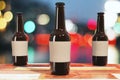 Three brown beer bottles on wooden table outdoor Royalty Free Stock Photo