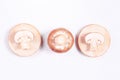 Three brown champignons on a wooden stand on a white background Royalty Free Stock Photo