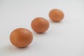 Three brown eggs in a line over white background Royalty Free Stock Photo