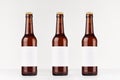 Three brown longneck beer bottles 330ml with blank white label on white wooden board, mock up. Royalty Free Stock Photo