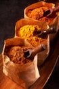 Three brown paper bags filled with ground spice