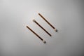 Three brown and white matches. White background, some matchbooks. Wooden matchsticks