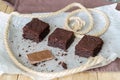 Three brownie pieces and broken chocolate on baking paper Royalty Free Stock Photo