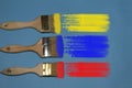 Three brushes with paint samples.