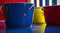 three buckets of different colors sitting on a counter top with a red, yellow, and blue bucket in the middle of the photo Royalty Free Stock Photo