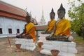 Three Buddha statues in front of the Wat Phra Borommathat Chaiya Ratcha Worawihan temple in Surat Thani, Thailand.