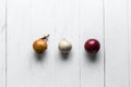 Three bulbs on a white wooden background. White onions, onions and red onions. Top view. Royalty Free Stock Photo