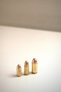 Three bullets of different calibers on a white surface.