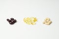 Three bunches of multivitamins, fish oil and astaxanthin. Omega-3 in the middle. White background. Close-up