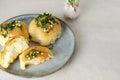 Three buns with garlic and dill sauce with oil in a gray plate. Preparation of pampushky (Pampushky)