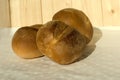 Three buns of wheat flour on a white tablecloth. Belgian bread. Closeup Royalty Free Stock Photo