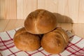 Three buns of wheat flour on a white towel with red stripes. Belgian bread. Closeup Royalty Free Stock Photo