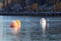 Three buoys reflecting in ice