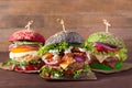 Three burgers with different bread buns on wood background Royalty Free Stock Photo