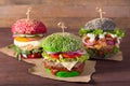 Three burgers with different bread buns on wood background Royalty Free Stock Photo