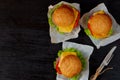 Three burgers with falafel, salad, cheese, tomatoes and fork on the black background. Traditional Middle Eastern fast food