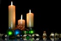 Three burning candles with Christmas ornaments