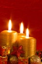 Three burning candles in a Christmas setting