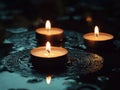Three Burning Candles Reflecting on a Dark Water Surface Royalty Free Stock Photo