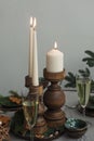 Three burning candles on a table in wooden candlesticks, two glasses with champagne, spruce branches Royalty Free Stock Photo