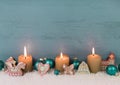 Three burning candles on wooden blue shabby wooden background. Royalty Free Stock Photo