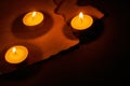 Three burning circle candles and ancient burnt paper sheets Royalty Free Stock Photo