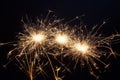 Three burning New year sparklers on black background Royalty Free Stock Photo