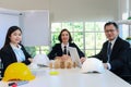 Three business people have discussing about building plan in meeting desk, engineer team work together on construction project in Royalty Free Stock Photo