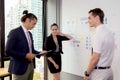 Three business people in modern office looking report and analyzing with talking in meeting room. Royalty Free Stock Photo