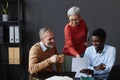 Three business people with senior workers collaborating Royalty Free Stock Photo