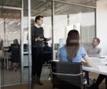 Three business people sitting, standing, and discussing during a business meeting Royalty Free Stock Photo