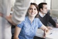 Three business people sitting, standing, and discussing during a business meeting Royalty Free Stock Photo