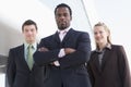 Three business people standing outdoors by buildin