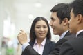 Three business people talking and looking at wall, arm raised Royalty Free Stock Photo