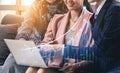 Business professionals collaborating on financial data analysis with laptop and graphs in modern office setting Royalty Free Stock Photo