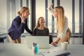 Three business women in modern office celebrating good project results Royalty Free Stock Photo