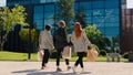 Three business women with shopping bags at lunch time came back to work walking together to the high business building Royalty Free Stock Photo