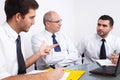 Three businessman sitting at table during meeting