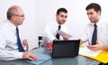 Three businessman sitting at table during meeting