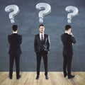 Three businessmans in suit with drawing question marks over head Royalty Free Stock Photo